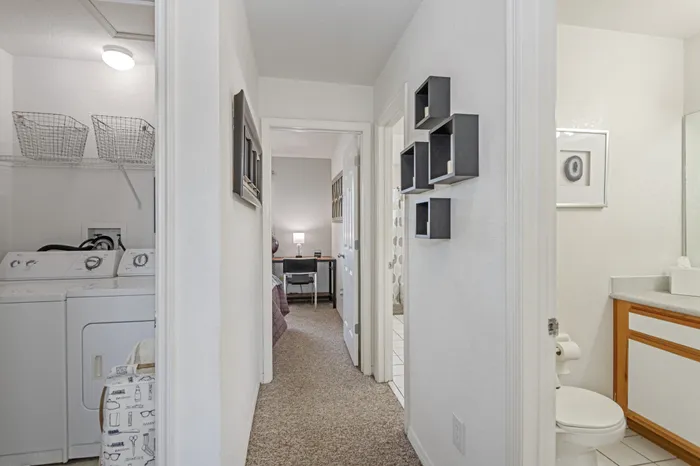 model unit upstairs hallway showing laundry room, bathroom, and back bedroom.