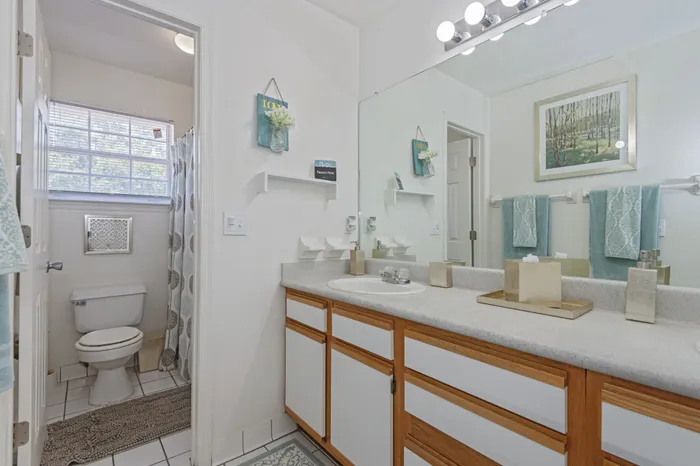 model unit bathroom with duel sink, toilet, and shower.