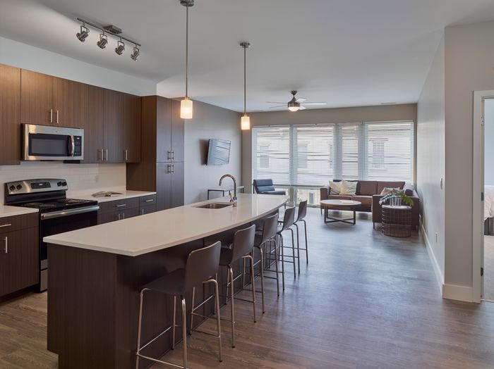 the simon at founders row. kitchen with island, stove/oven, and microwave.