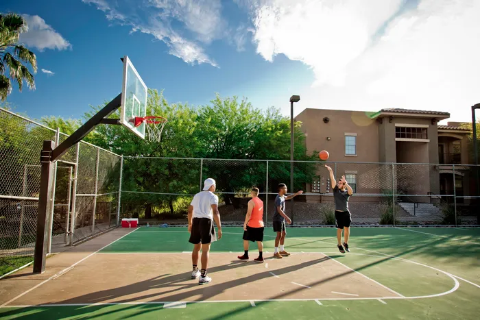 students playing basketball at ua off campus housing complex