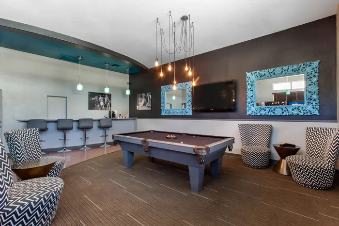 campus crossings at star pass clubhouse area with pool table, chairs, and bar stools.