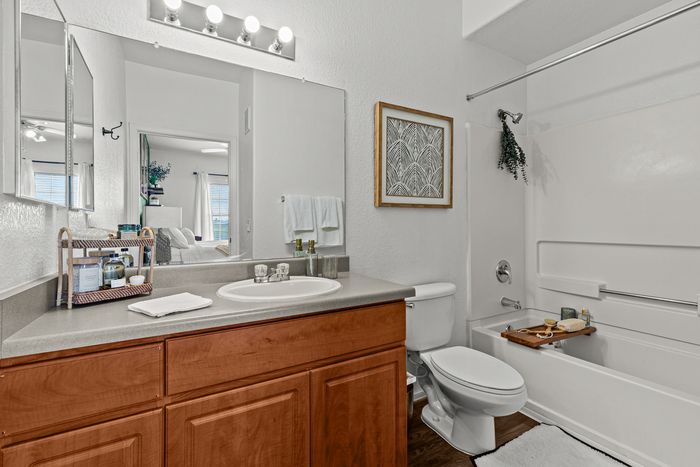 campus crossings at star pass model unit bathroom with sink, toilet, and shower tub.
