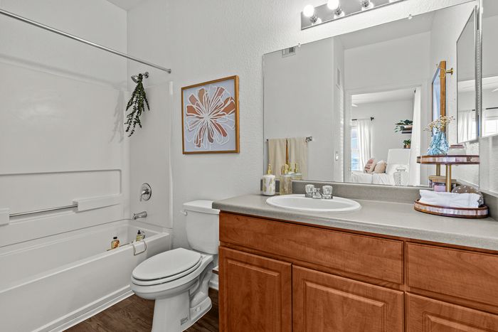 campus crossings at star pass model unit bathroom with sink, toilet, and shower tub.