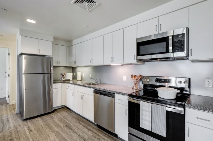 campus crossing at college row model unit kitchen with stainless steel appliances stove, microwave, and dishwasher. lancaster pa franklin & marshall