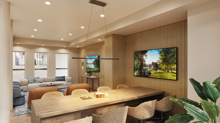 renovated resident lounge with long tables, tvs, and chairs.