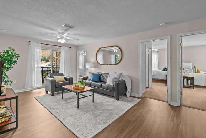 abbey west athens georgia model unit living area with couch, chairs, coffee table and tv with stand.