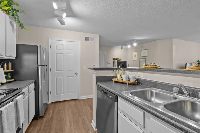 abbey west athens georgia model unit kitchen area with stainless steel appliances including refrigerator, stove/oven, dishwasher, and sink.