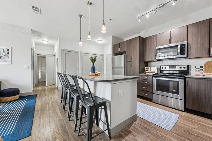 tenn student living knoxville model unit kitchen with island and stools and stainless steel appliances