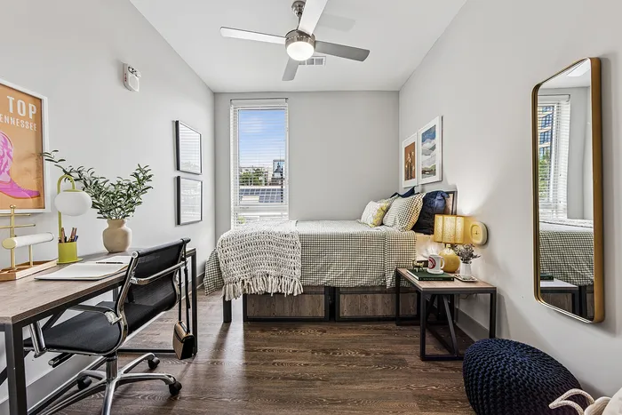 tenn student living knoxville mode unit bedroom with bed, storage drawers and desk.