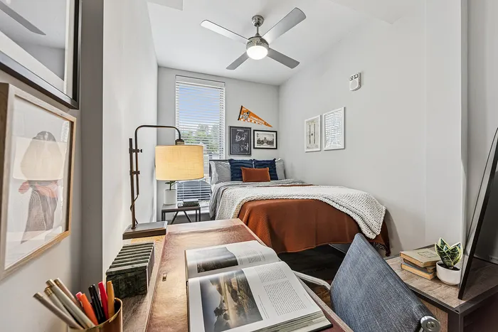 tenn student living knoxville mode unit  bedroom with bed, desk, and drawers.
