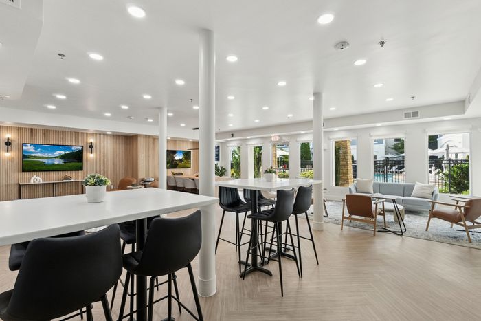 renovated resident lounge with coffee machine, counter top, and chairs.