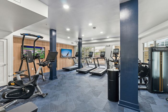 campus crossings briarcliff renovated fitness enter with bikes, pull up machine, and tvs.
