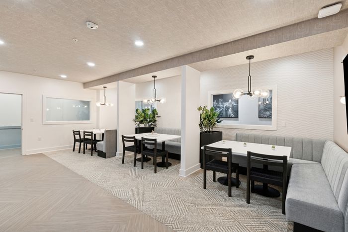 campus crossings briarcliff renovated resident lounge with booths, chairs, and tables.