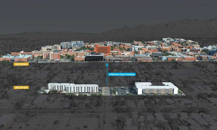 Aerial view showcasing the proximity of modern apartment buildings just 2 blocks from a vibrant campus, nestled between 6th and 8th streets with scenic mountain views in the background.