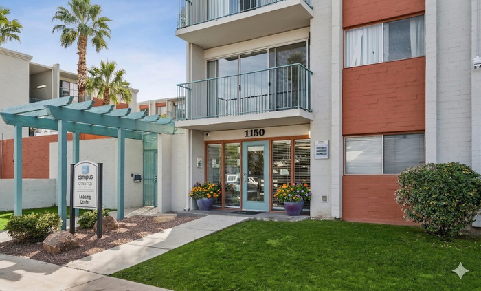 Charming apartment building with modern facade, lush greenery, and inviting entrance at Campus Crossings.
