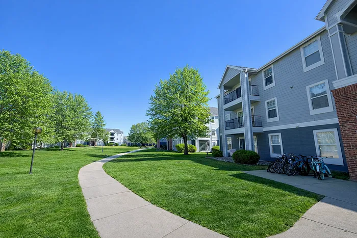 Charming apartment complex surrounded by lush greenery, offering a serene living experience with bicycle-friendly pathways.