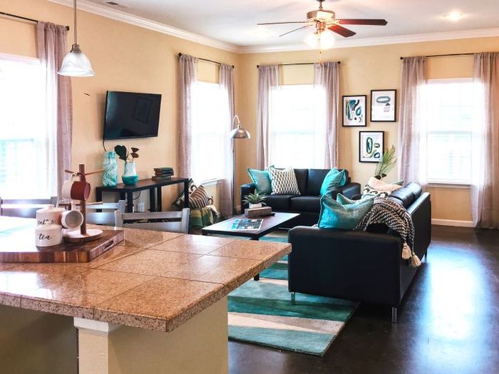 Inviting open-concept living room with modern decor, cozy couches, and ample natural light, perfect for relaxation.