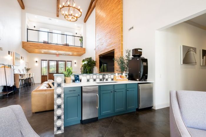 Bright and modern open-concept living space with loft-style design, showcasing elegant lighting and a stylish kitchen area.