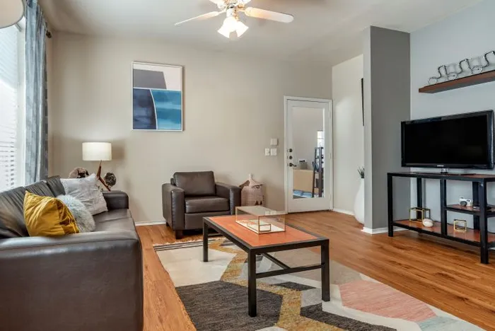 Chic living room with modern furniture, wooden flooring, and stylish decor, creating a warm and inviting atmosphere.