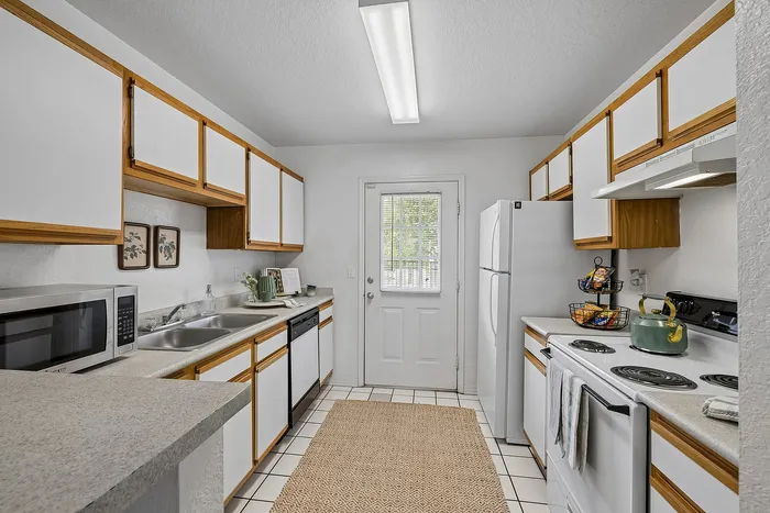 Bright and inviting kitchen with modern appliances, ample cabinetry, and a chic countertop arrangement.