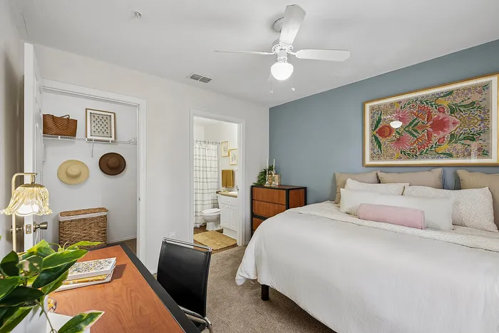 Inviting bedroom with cozy bedding, elegant wall art, and attached bathroom, perfect for relaxation.