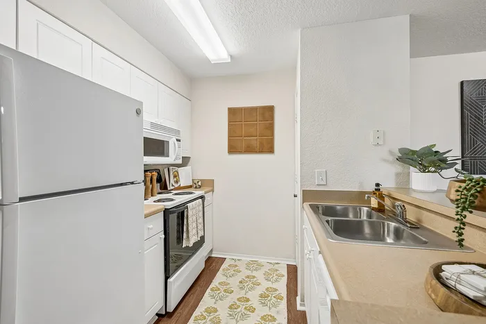 Bright and inviting kitchen with modern appliances, sleek countertops, and elegant white cabinetry.
