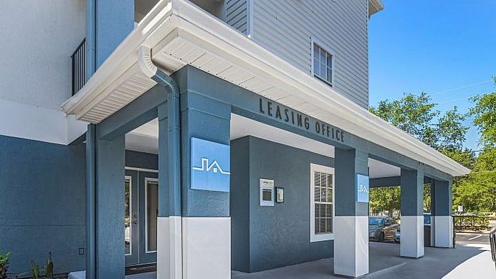 Inviting leasing office entrance with modern architecture and vibrant landscaping, perfect for prospective tenants.