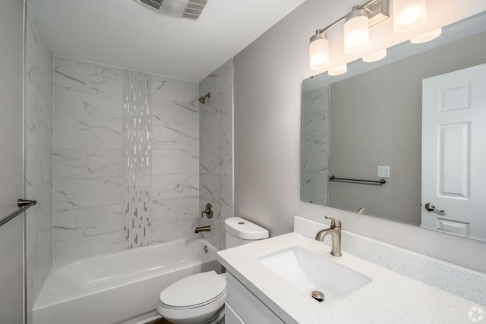 Contemporary bathroom with elegant marble tile, modern fixtures, and soft ambient lighting.