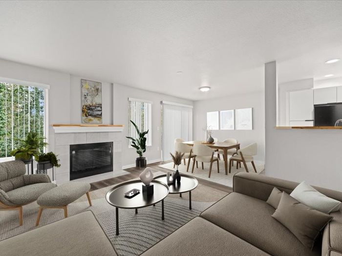 Elegant living room with modern furniture, cozy fireplace, and bright dining area, offering a spacious and inviting atmosphere.