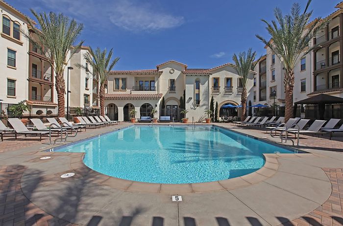 Expansive pool plaza with tanning deck at Highlander at North Campus in Riverside, California