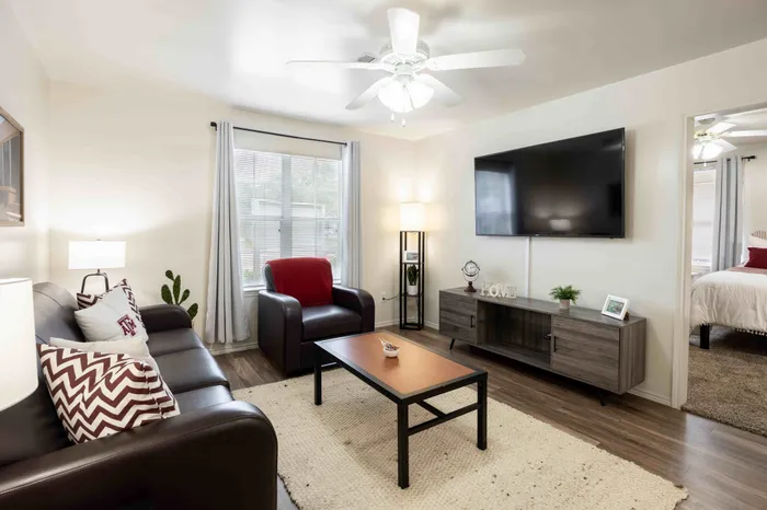 Bright living room with large windows at The Zone student apartments near TAMU in College Station Texas