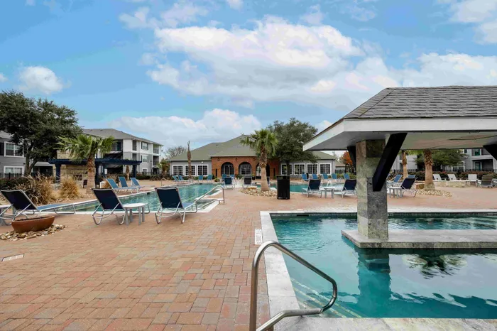 Resort-style pool with swim-up bar at The Zone student apartments near Texas A&M University in College Station TX