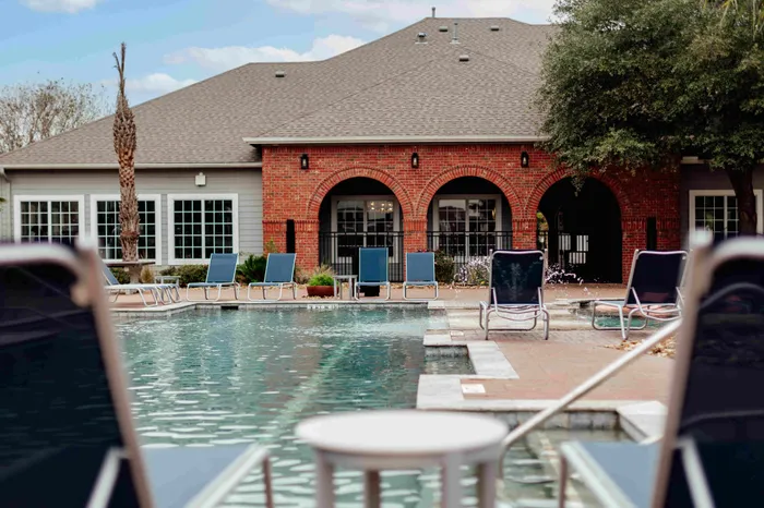 Resort-style pool with lounge chairs at The Zone student apartments near Texas A&M University in College Station TX