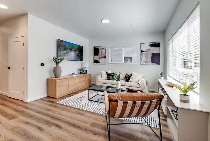 Open-concept living room with wood-style flooring at The Preserve on Goodpasture apartments Eugene Oregon