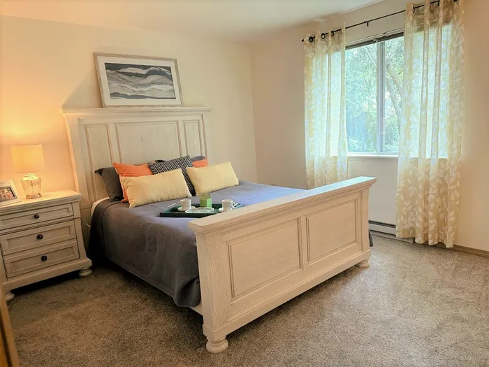 Bright and inviting bedroom with a cozy bed, elegant side table, and stylish decor.