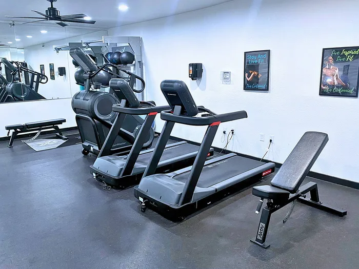 24/7 Centennial Ridge Modern fitness room with state-of-the-art treadmills, exercise bench, and gym equipment.