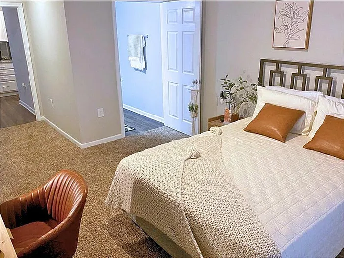 Elegant Centennial Ridge bedroom with modern decor, featuring a plush bed, stylish chair, and artistic wall art.