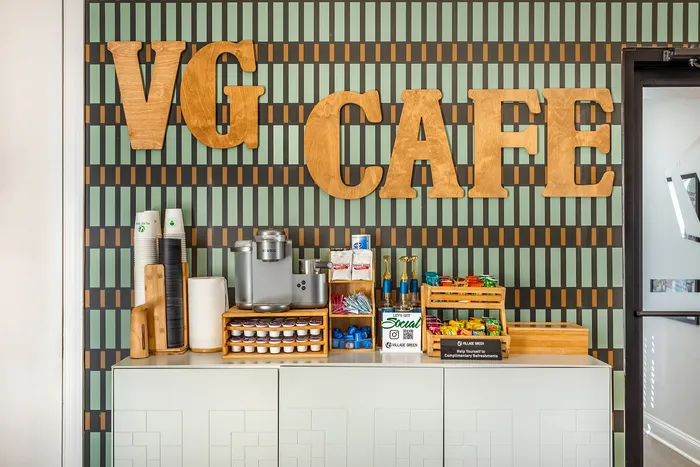 Stylish beverage corner with sleek design and wooden 'VG Cafe' sign at Village Green in Raleigh, North Carolina.