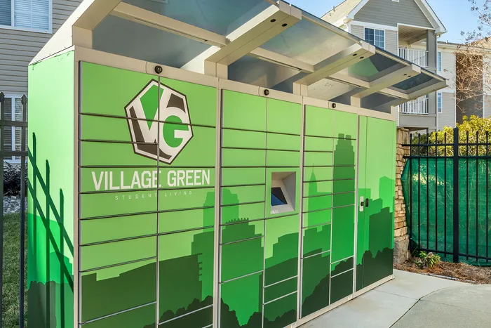 Village Green parcel locker with green branding located in a modern residential area.
