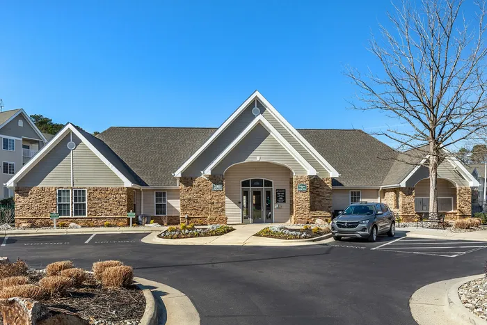 Inviting exterior of a community clubhouse with attractive stone accents and modern design Village Green in Raleigh, North Carolina.