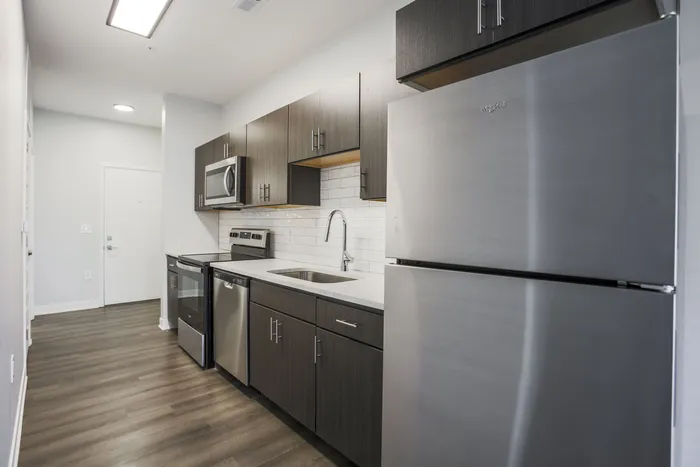 Modern kitchen with sleek stainless steel appliances, dark wood cabinetry, and contemporary design elements. West Lafayette, Indiana. Near Purdue.