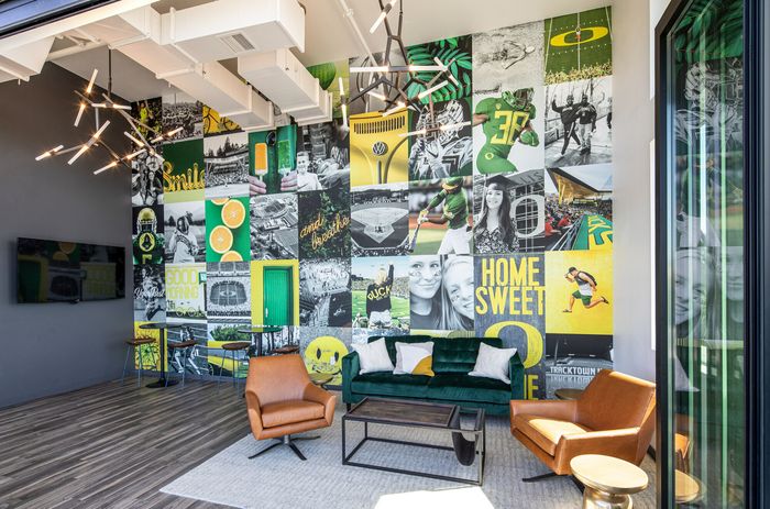 Vibrant lounge with eclectic wall art, featuring cozy seating, a modern chandelier, and natural light streaming in, perfect for relaxation and inspiration.