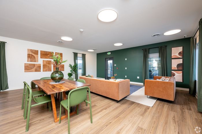 Contemporary living space featuring elegant wood finishes, green accents, and cozy seating with a stylish modern dining area.
