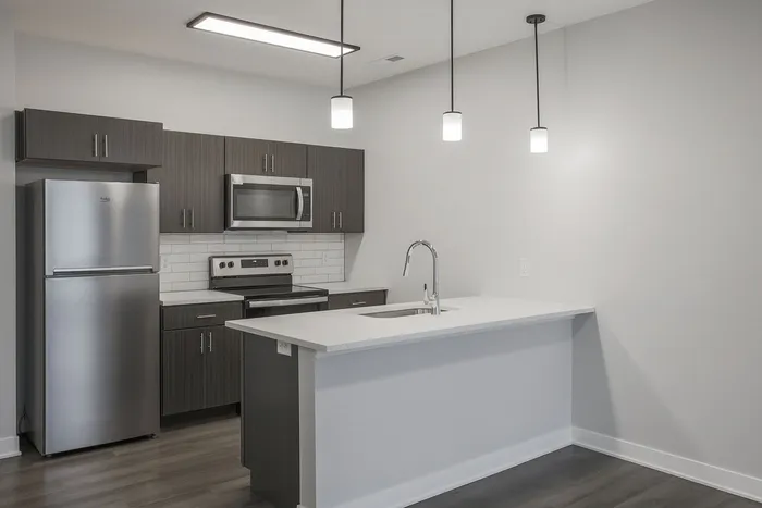 Modern kitchen with sleek dark wood cabinets, stainless steel appliances, and elegant pendant lighting over a pristine white island.