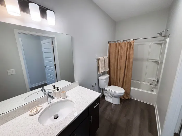 Modern bathroom with sleek fixtures, elegant vanity, and spacious bathtub, offering a stylish and serene retreat.