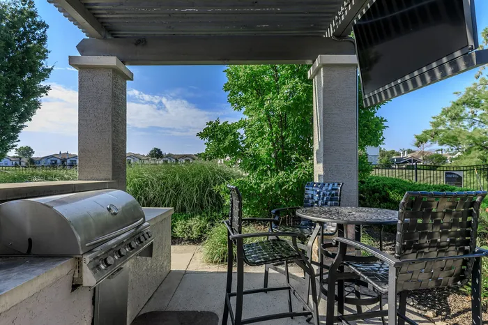 Second outdoor grilling and lounge patio with seating surrounded by greenery at Corbin Crossing Overland Park KS