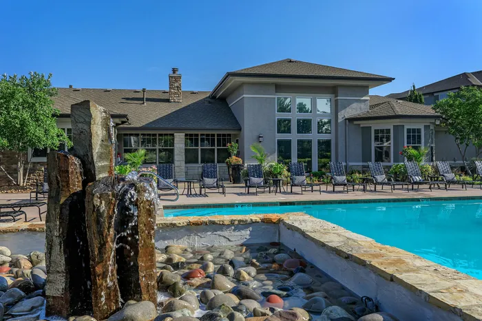 Resort-style pool with stone fountain feature and apartment buildings at Corbin Crossing Overland Park KS