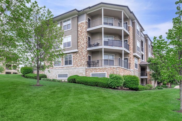 Apartment building with spacious private patios and balconies surrounded by manicured lawns at Corbin Crossing KS