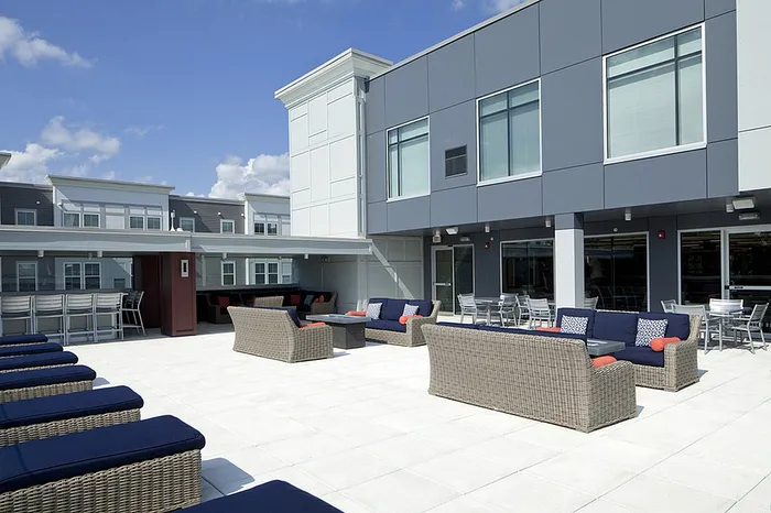 Chic rooftop lounge with stylish wicker furniture and a sunny outdoor seating area, perfect for entertaining and relaxation.