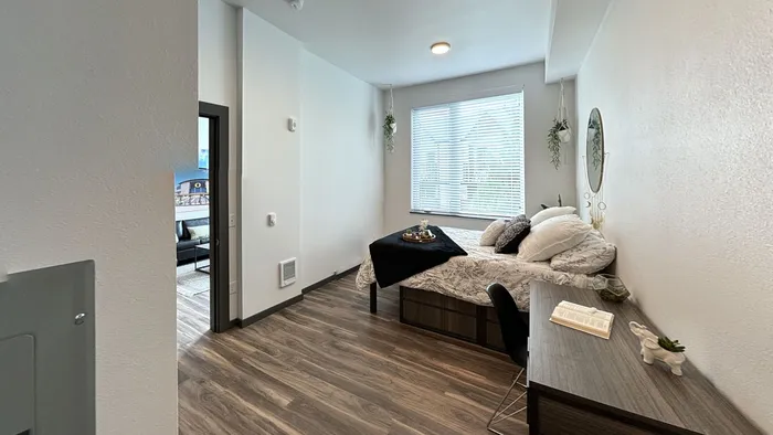 Bright cozy bedroom with wooden flooring and natural light at The Flats at Chase in Eugene, OR